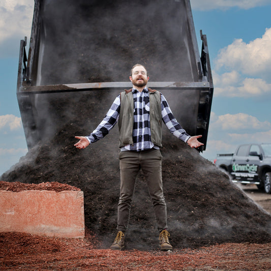 woodrow standing in front of a delivery truck dropping off mulch